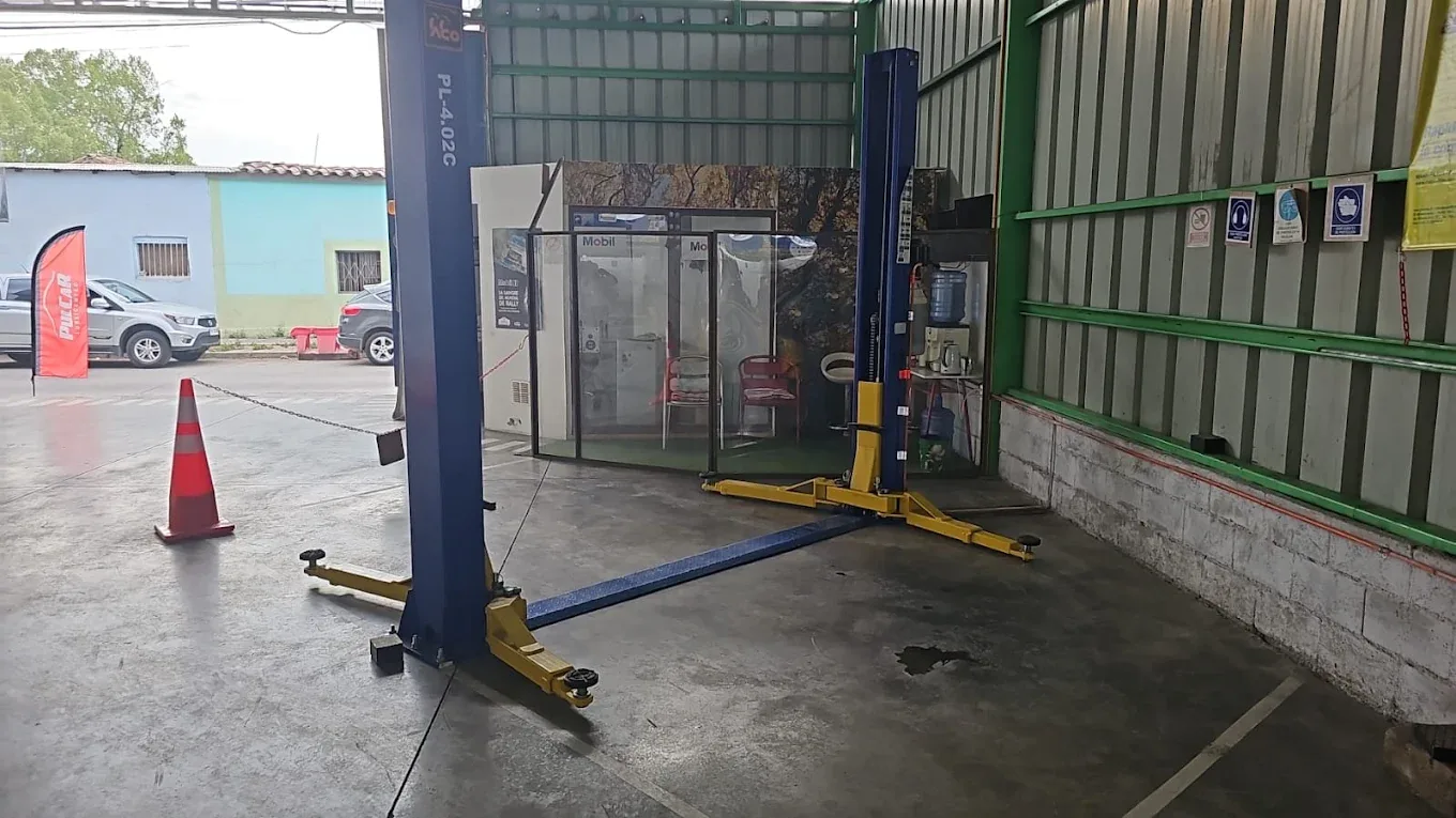 Interior del taller de Lubricentro PulCaR con elevador de dos columnas